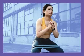 person doing a squat, using a resistance band on thighs